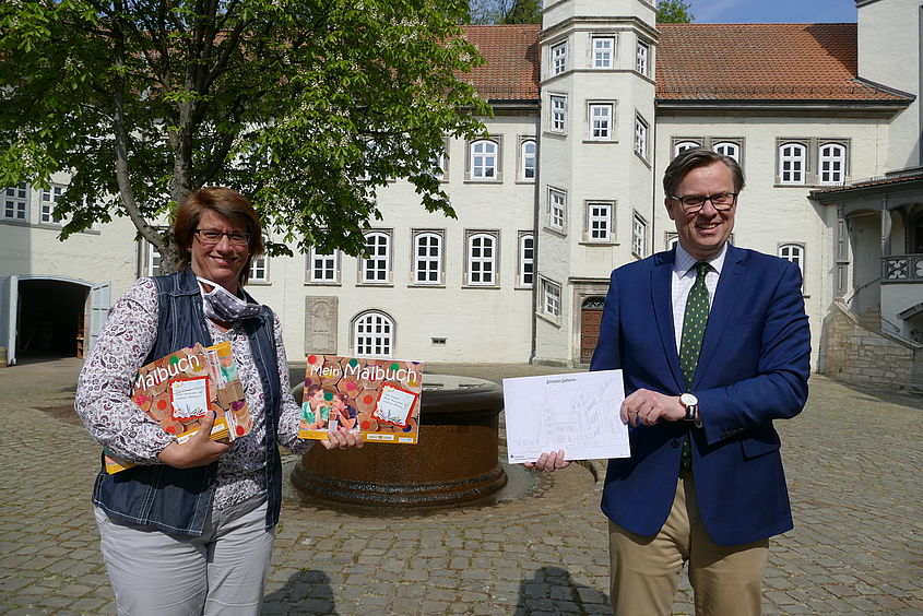 Landrat Dr. Andreas Ebel überreichte der Leiterin des Gifhorner Frauenhauses, Hella von Wedemeyer, einen Stapel Malbücher, um die Kinder besonders in Zeiten des Coronavirus zu beschäftigen.