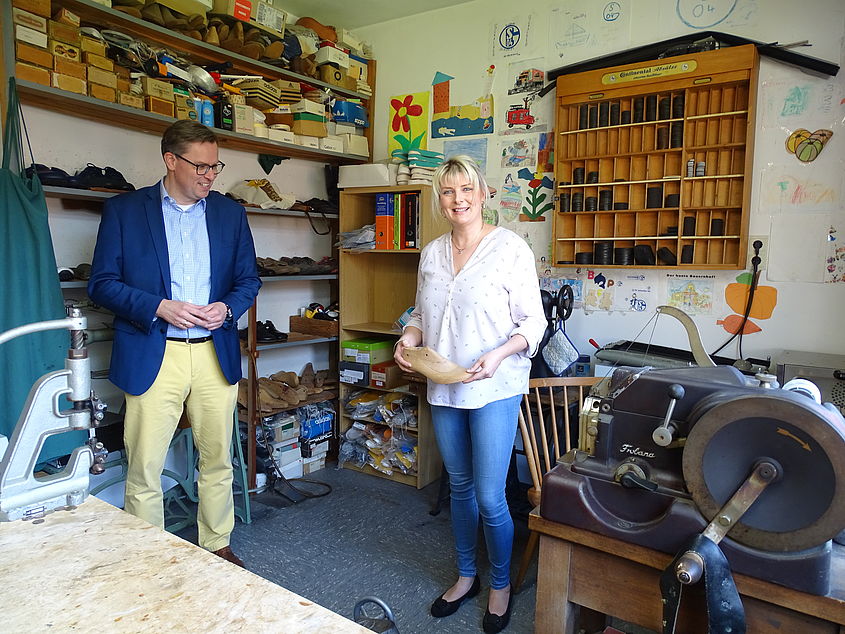 Stefanie Heers führte Landrat Dr. Andreas Ebel in die Schuhmacherwerkstatt des Schuh- und Sporthauses Heers.