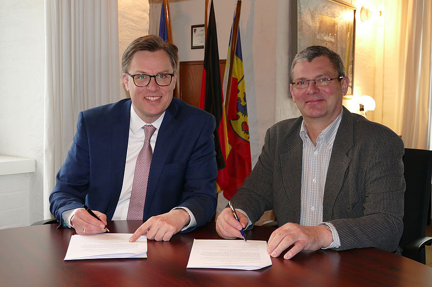 Landrat Dr. Andreas Ebel (links im Bild) und Jörg Liedtke, Eigentümer der Gifhorner Cardenapmühle, unterzeichnen den Vertrag zur Ablösung des Alten Wasserrechtes für die Cardenapmühle.